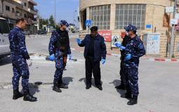 الشرطة الفلسطينية خلال اتخاذ اجراءات وقائية ضد فيروس كورونا