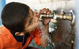 طفل يشرب مياه من أحد المحطات الخاصة بغزة