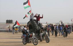 فلسطينيون يرفعون علم فلسطين في مسيرة العودة الكبرى