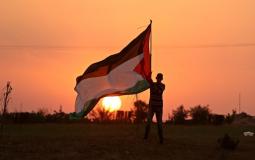 شاب يرفع علم فلسطين - توضيحية