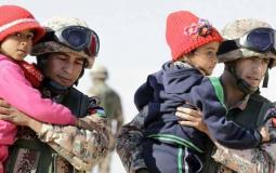 جنود أردنيون يساعدون لاجئين بدخول الأراضي الأردنية