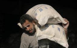 لاجئ فلسطيني يتسلم مساعدة من الأونروا في غزة
