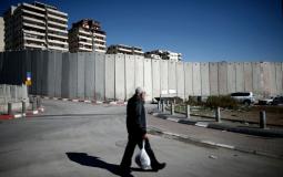 فلسطيني يمر قرب الجدار االذي يحيط بمخيم شعفاط