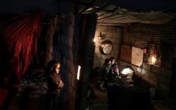 مواطنون من شمال غزة يجلسون في ظل انقطاع التيار الكهربائي