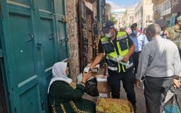 أحد أفراد الشرطة يقوم بتوزيع الكمامات على المواطنين
