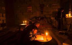 طفل يؤدي واجباته المدرسية في بيته بغزة أثناء انقطاع الكهرباء