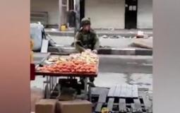 جندي إسرائيلي يسرق تفاحة بالخليل