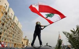 سيدة لبنانية ترفع العلم اللبناني