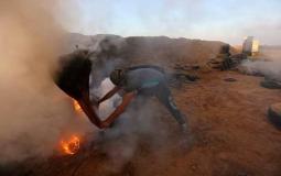 متظاهر يحاول إخماد حريق أحدثته الطائرة الإسرائيلية بعدما قذفت قنابل حارقة صوب الخيام