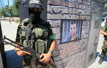 عنصر من القسام يقف بجانب مجسم لسجن الجنود الإسرائليين بغزة