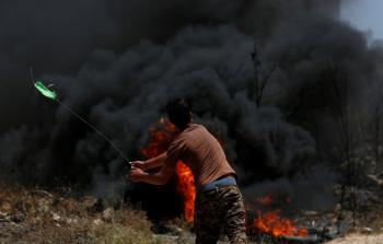 فلسطيني يلقي الحجارة على جنود الاحتلال جنوب نابلس