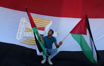 فلسطيني يحمل العلمين المصري والفلسطيني