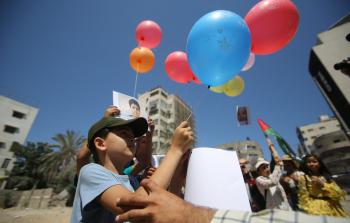 صورة لأحد الأطفال وهو يطلق بالونا يحمل رسائل انسانية الى العام