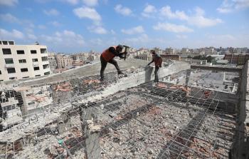 عمال فلسطينيون يعملون على إزالة ركام بناية مدمرة في غزة