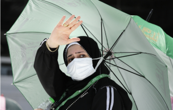 صورة لحاجة وهي تلقي السلام على رجال الأمن في ساحة الحرم المكي اليوم أثناء أداء مناسك الحج