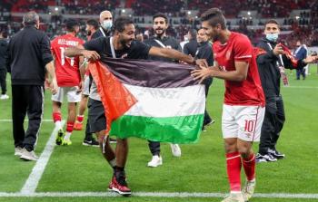 لاعبا الأهلي المصري محمود كهربا ومحمد شريف يرفعان علم فلسطين بعد التتويج بالسوبر الإفريقي