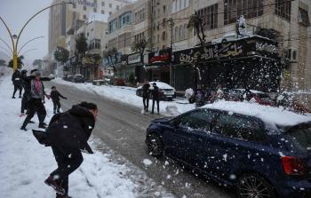 أطفال يعلبون بالثلوج في مدينة الخليل