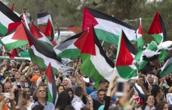 متظاهرون يحملون أعلام فلسطين