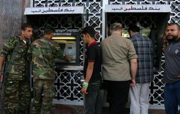 موظفون يسلمون الرواتب من بنك فلسطيني