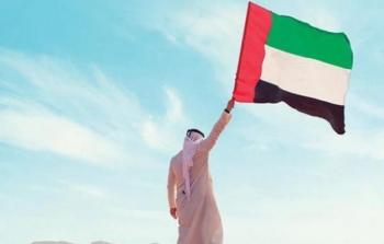 مواطن إماراتي يرفع علم الإمارات