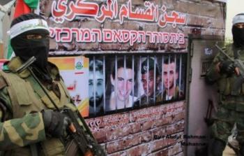 عنصران من حماس مع جدارية للأسرى الإسرائيليين - تعبيرية