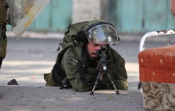 جندي إسرائيلي يصوب سلاحه على الفلسطينيين بالضفة - أرشيف