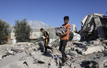 طلبة غزة يحملون كتبهم من البيوت المقصوفة في غزة - تعبيرية