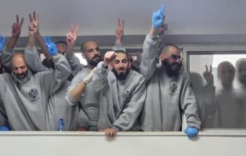 الأسرى المحررين ضمن الدفعة الثانية من صفقة التبادل يرفعون شارات النصر في مكان استقبالهم برام الله