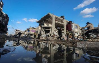 مواطنون يسيرون من أمام الدمار الذي خلّفه العدوان الإسرائيلي في حي الزيتون بمدينة غزة