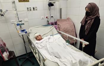 الطبيبة النجار برفقة طفلها العاشر الذي أصيب في الغارة (الأناضول)