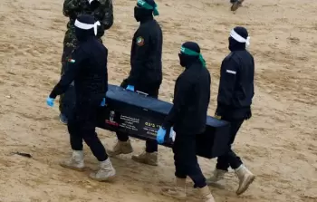 عناصر من المقاومة في غزة تسلم رفات أسير إسرائيلي