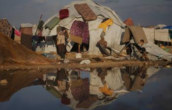 امرأة وطفل أمام خيمتهما في مخيم للنازحين على شاطئ مدينة غزة الثلاثاء (أ.ب)