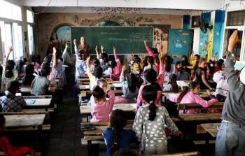 طالبات يتفاعلن مع مدرستهن في أحد الفصول الدراسية في مدرسة دير البلح