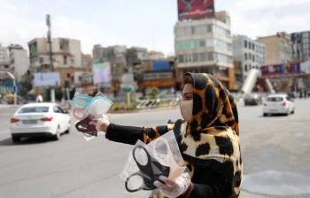 امرأة تبيع كمامات في إيران