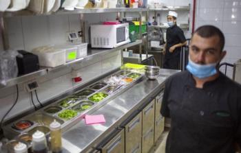 عمال يجهزون وجبات طعام في مطعم في تل أبيب أمس 