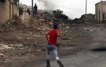 فتى فلسطيني يلقي حجرا