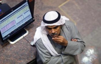 أحد المتعاملين في بورصة الكويت يتابع أسعار الأسهم 