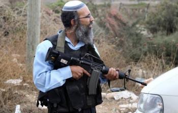 مستوطن يحمل رشاش آلي لمهاجمة المواطنين الفلسطينيين 