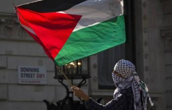 شاب فلسطيني يلوح بالعلم الفلسطيني في إحدى الدول الأوروبية