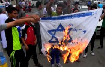 شبان فلسطينيون يحرقون علم اسرائيل  - إرشيفية -