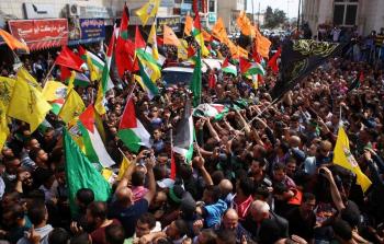 متظاهرون يرفعون أعلام فصائل فلسطينية