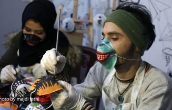 فنانان يُحولان الكمامات إلى لوحات فنية في غزة