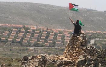 مواطن يرفع علم فلسطين في الضفة الغربية - ارشيف