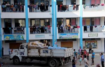 موظفو الأونروا خلال عملية توزيع المساعدات بإحدى مدارس غزة