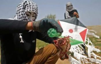 شبان من غزة يجهزون طائرة ورقية حارقة 