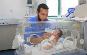 ممرض يقدم الحليب لطفل في احد المستشفيات بقطاع غزة