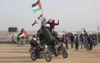 فلسطينيون يرفعون علم فلسطين في مسيرة العودة الكبرى