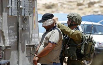 جندي اسرائيلي يعصب عينين فلسطيني معتقل