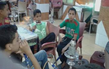أطفال من مصر يدخنون الشيشة بأحد المقاهي