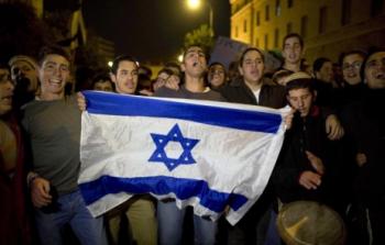 مستوطنون إسرائيليون يحملون العلم الإسرائيلي خلال مظاهرة على قرار إخلائهم من مستوطنة عمونة (الأوروبية)